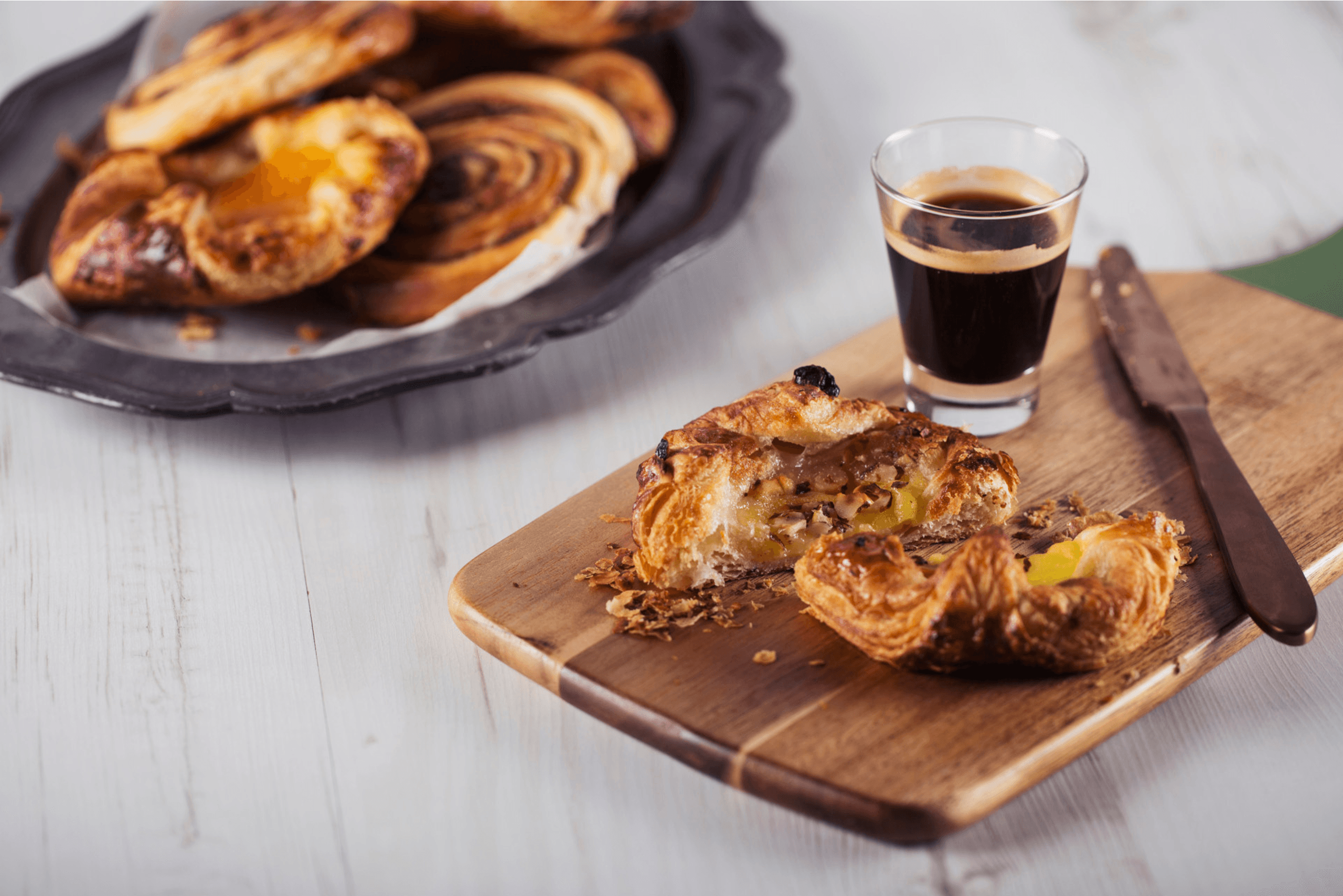 Pastries and a glass of espresso on a wooden board