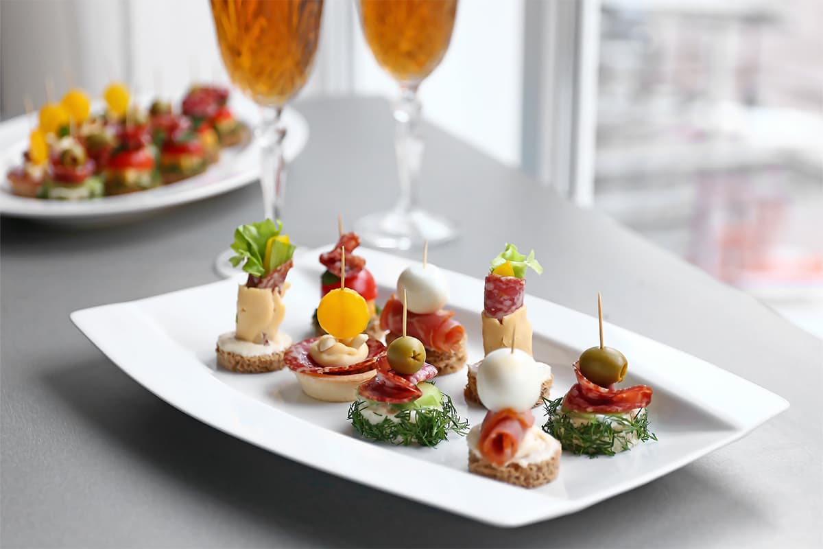 Canapés on a platter with glasses of fizz