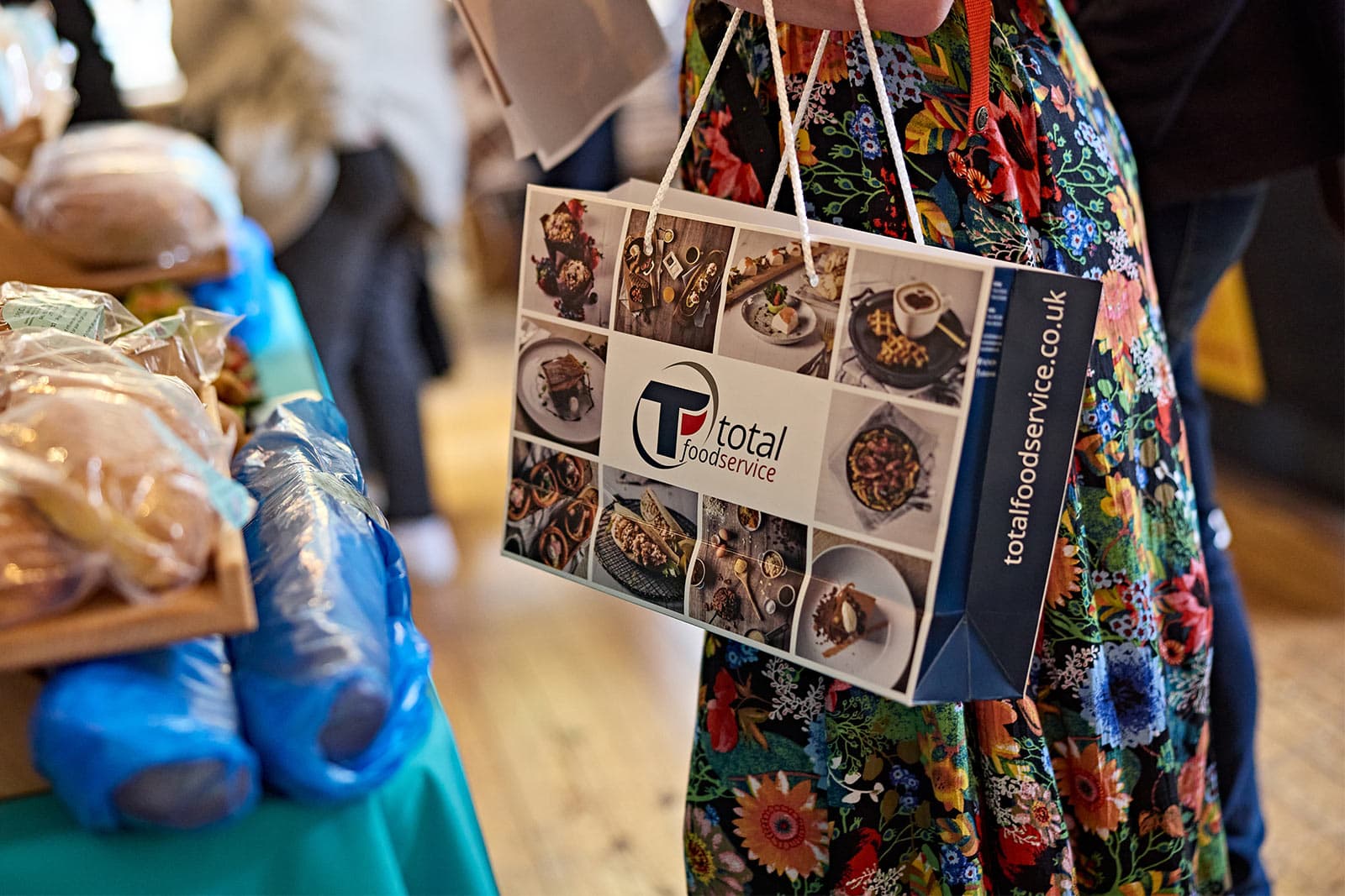 Visitor carrying a Total Foodservice bag at an event