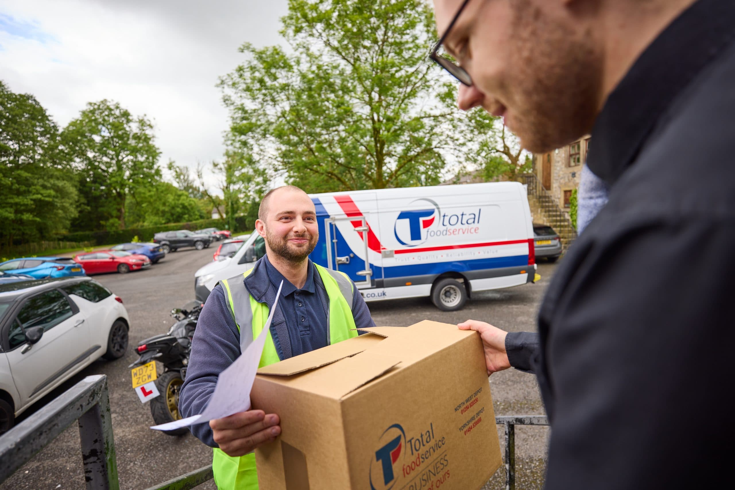 Total Foodservice driver handing a delivery to a customer