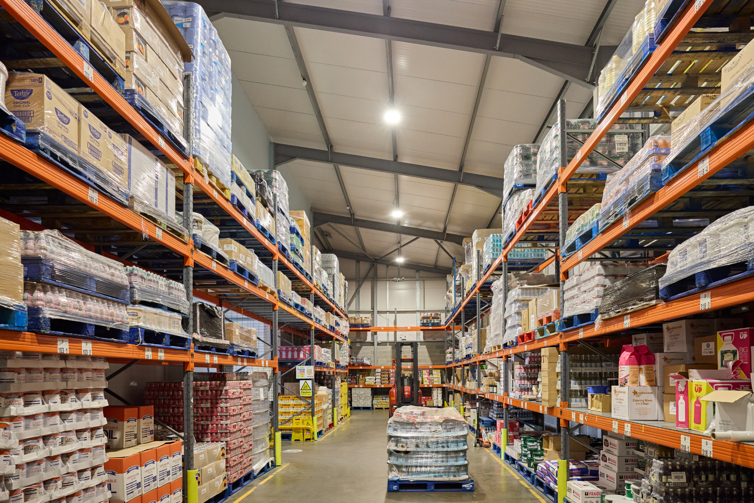 Warehouse aisle with racking stocked to the ceiling