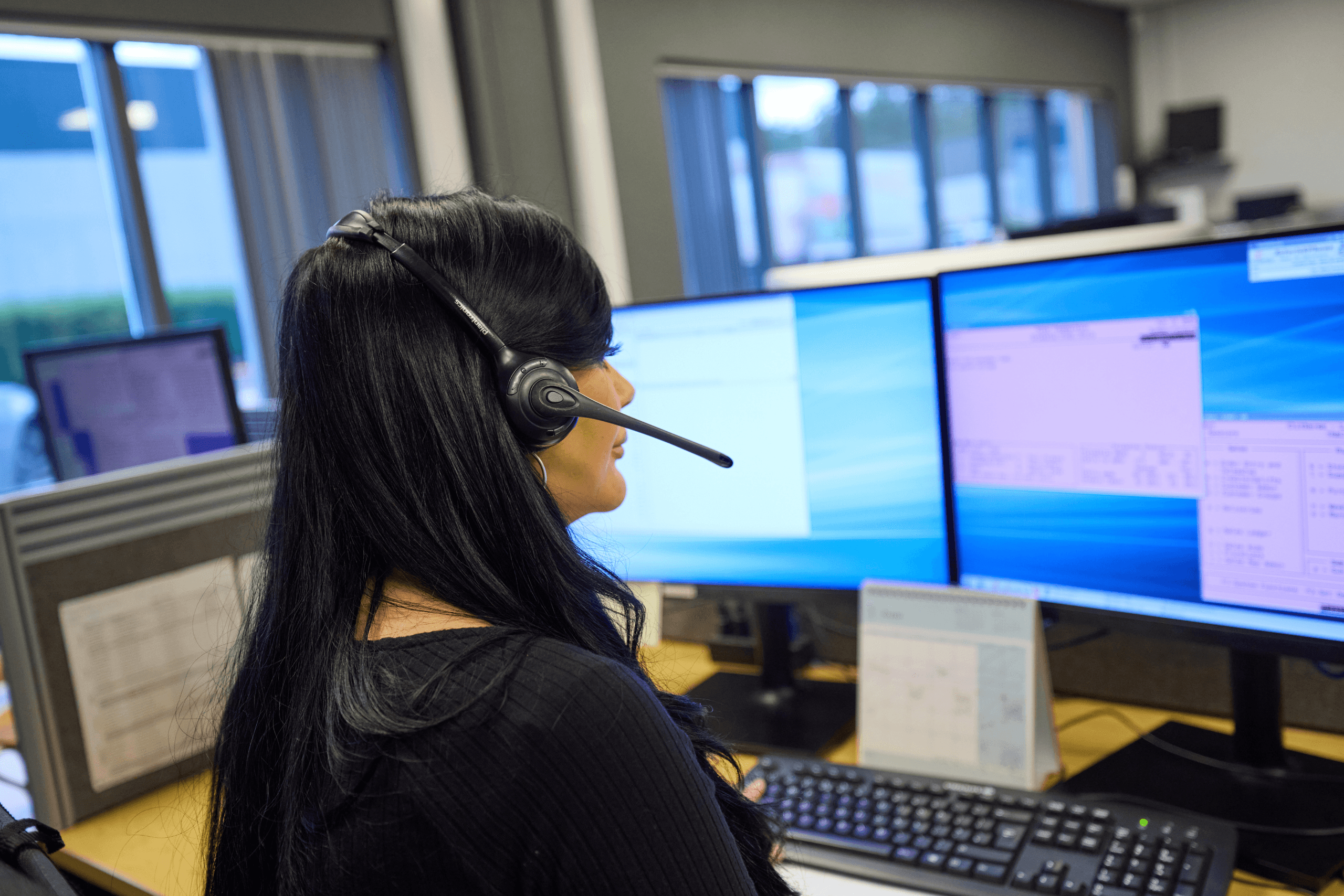 Telesales adviser in a headset at a computer