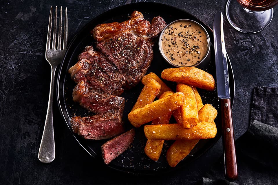 Steak with chunky chips and peppercorn sauce