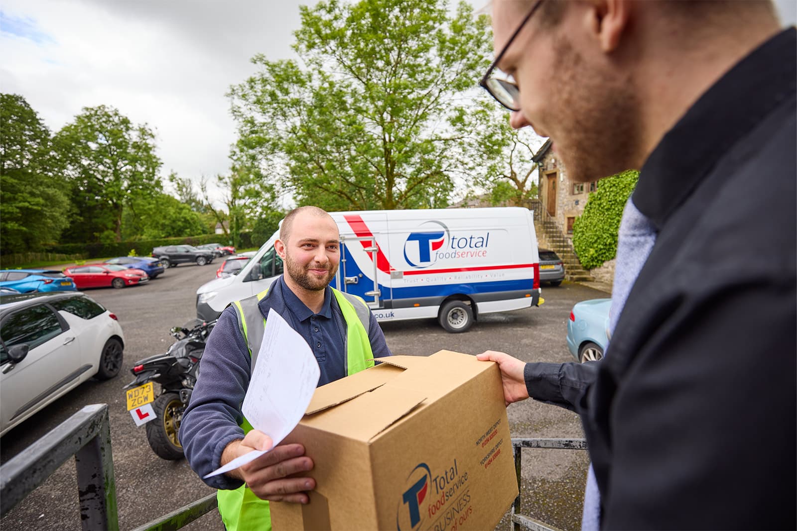 Total Foodservice driver handing a delivery to a customer