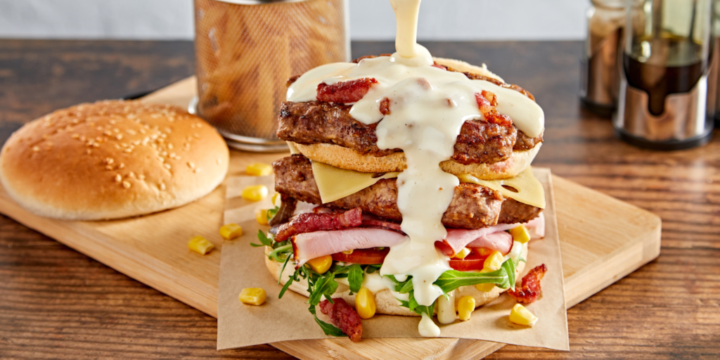Burger with ham, bacon and cheese sauce